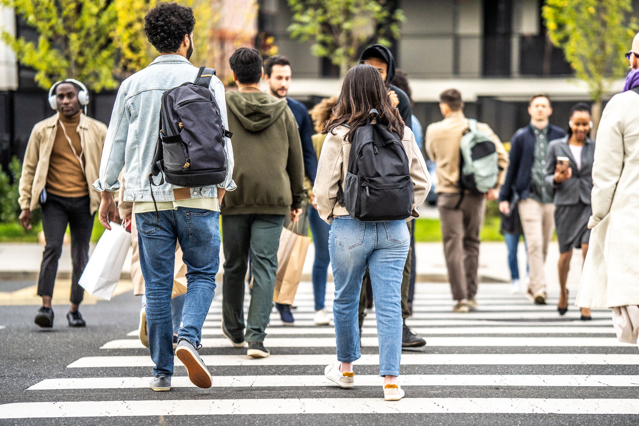 A pedestrian in Millbrook uses the crosswalk to safely cross the street.